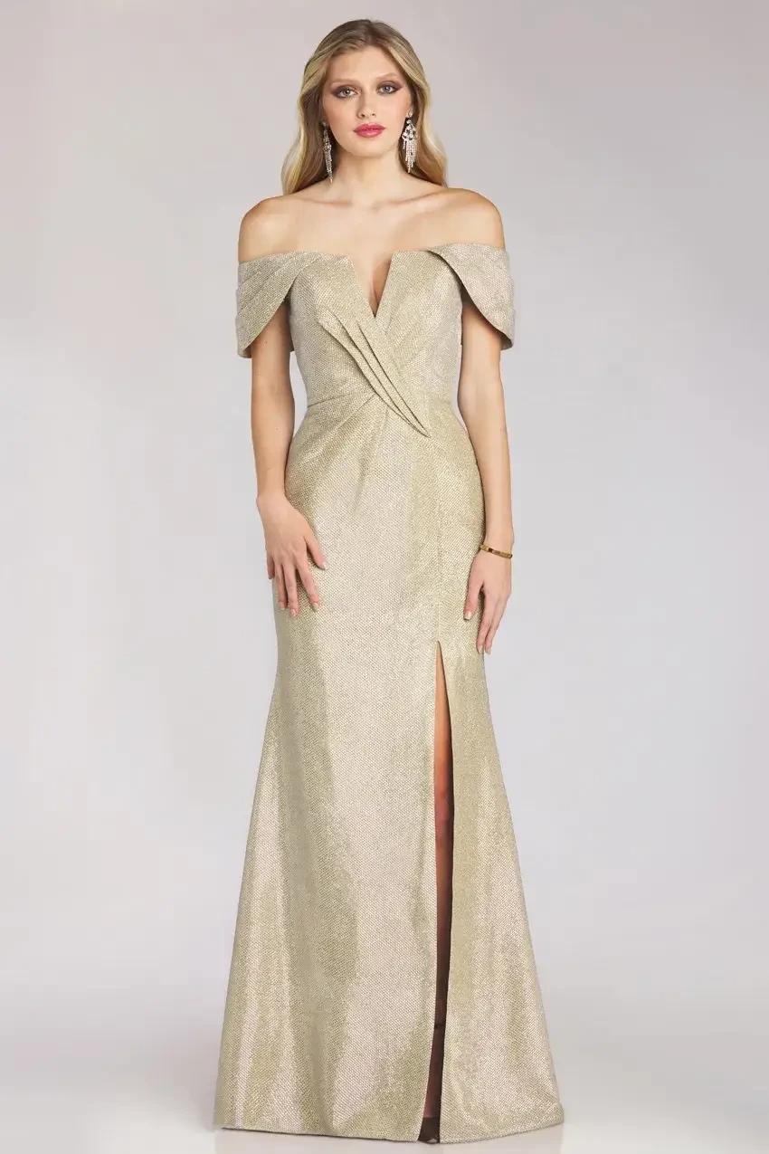 Model is wearing a metallic gold off-the-shoulder gown with a high slit and fitted silhouette.