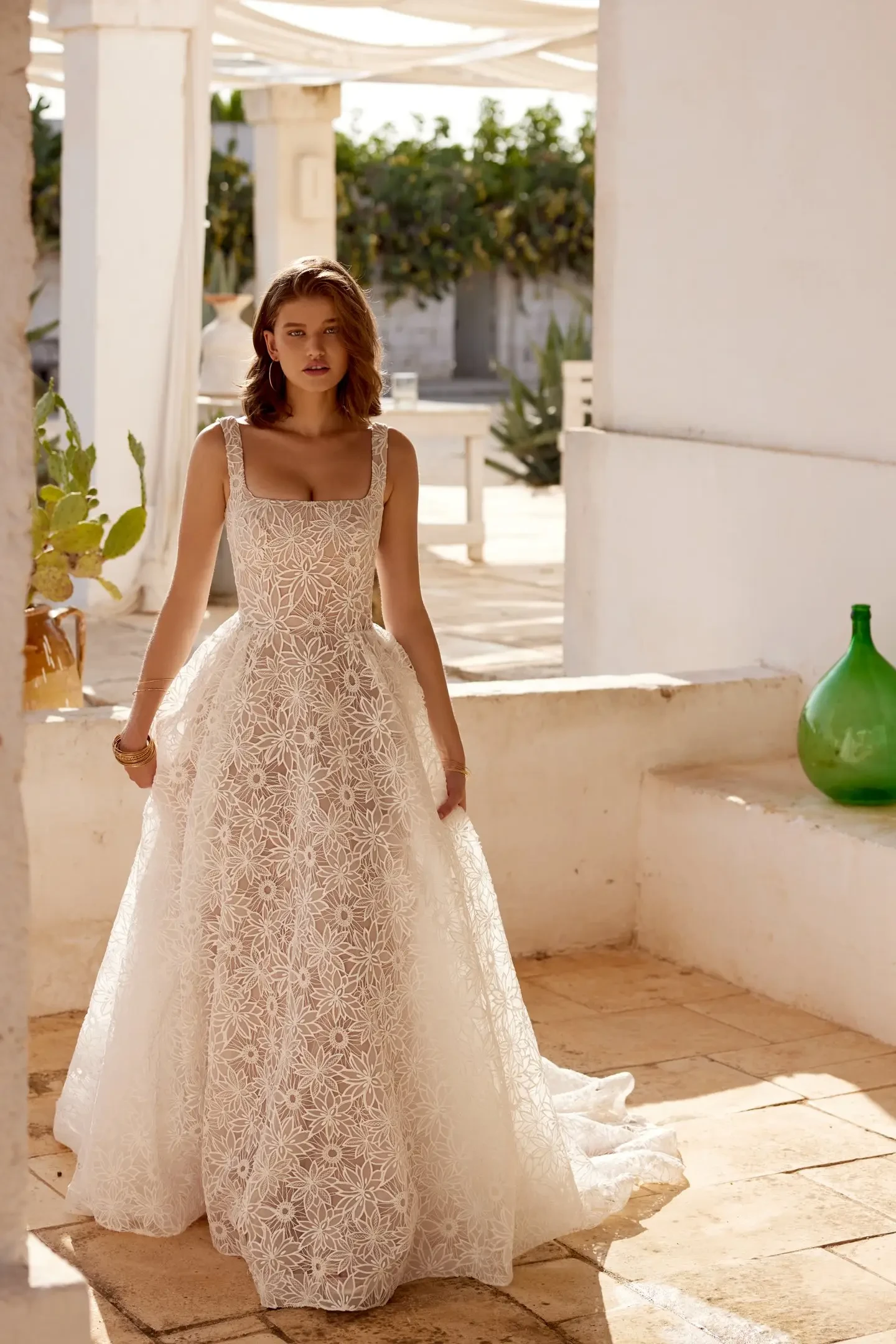 model is wearing a sleeveless a-line wedding dress with a square neckline