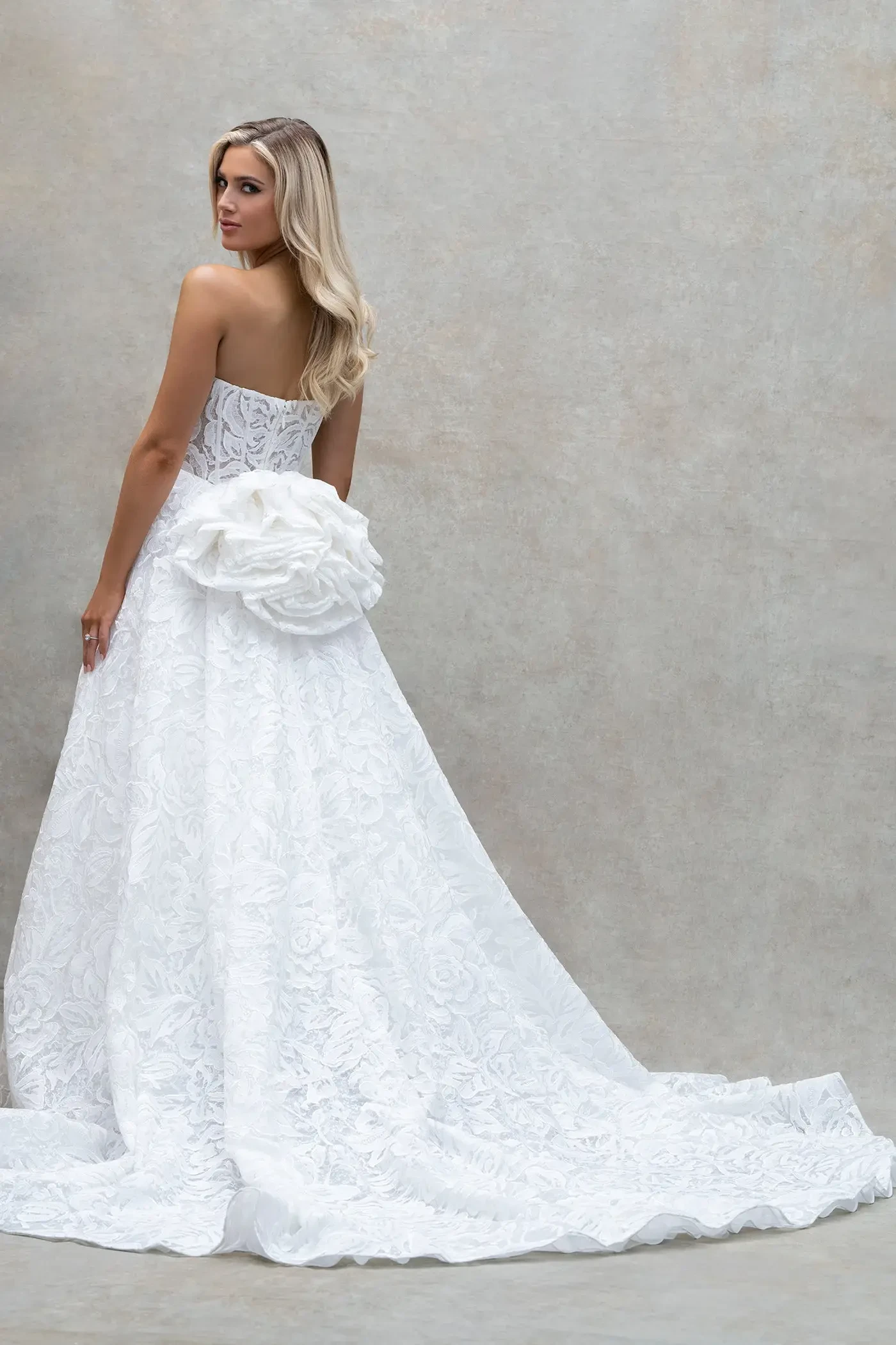 model is wearing a strapless a-line bridal gown with a flounce