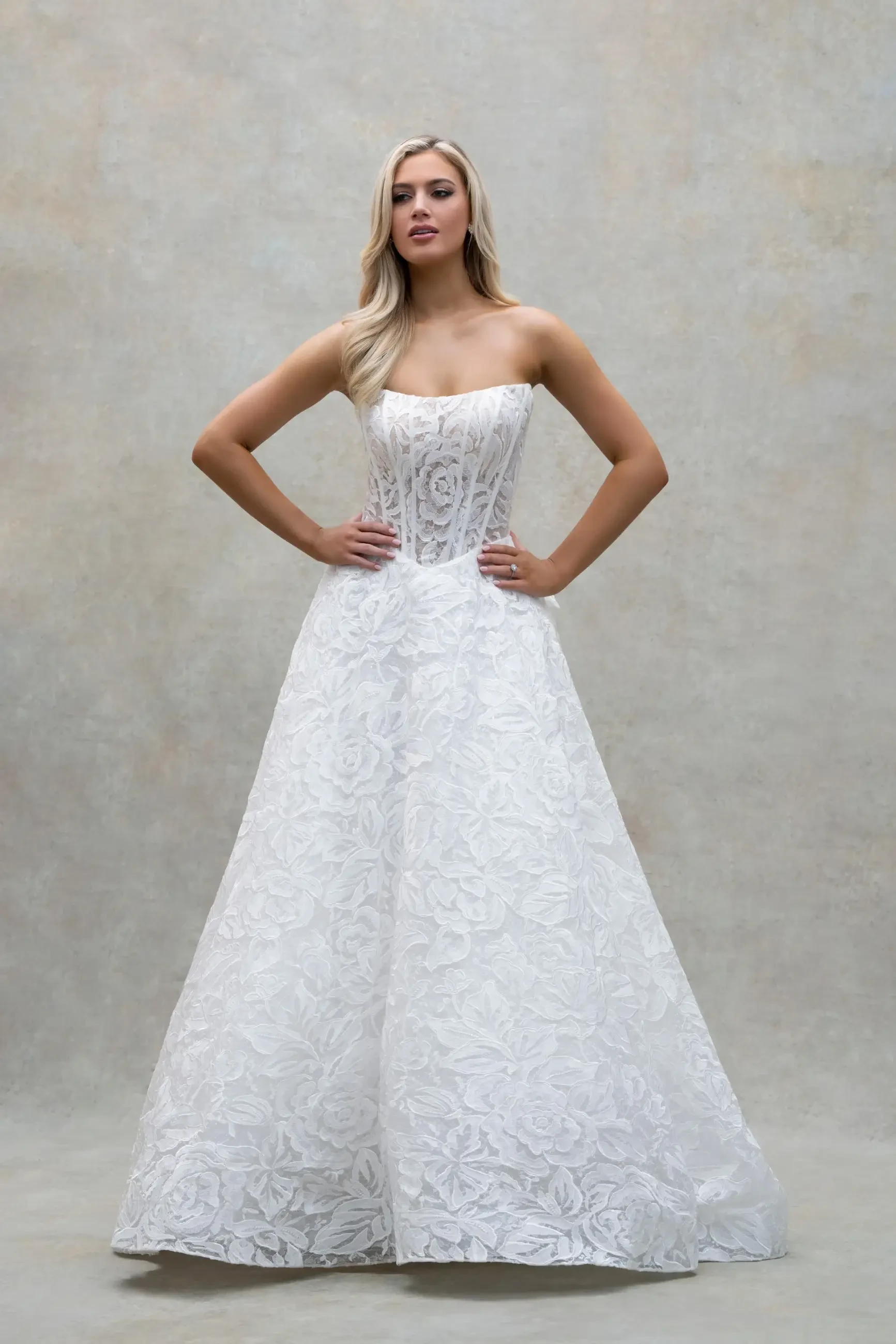 model is wearing a strapless a-line bridal gown with a flounce