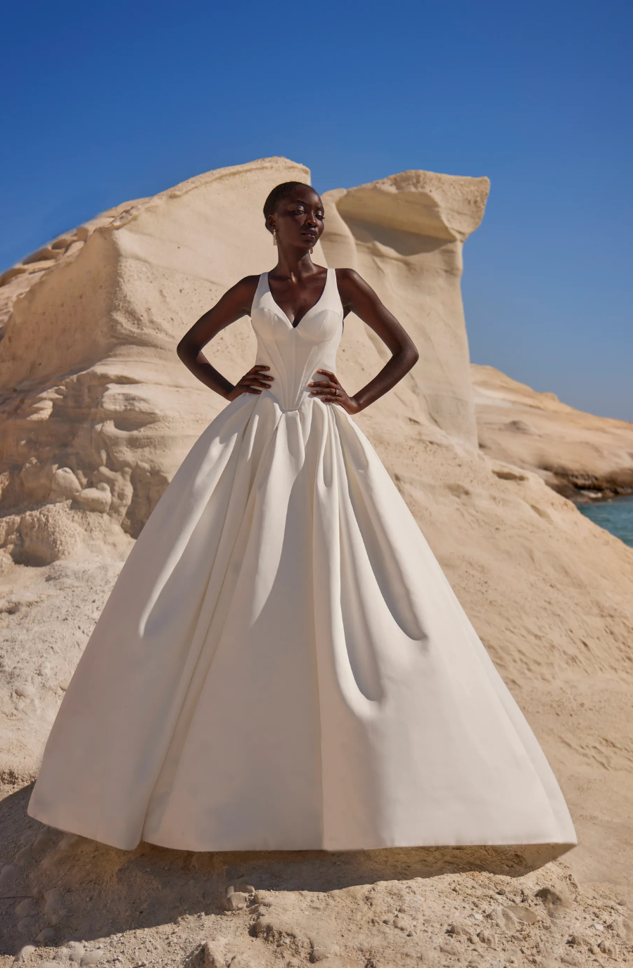 model is wearing a sleeveless ball gown wedding dress