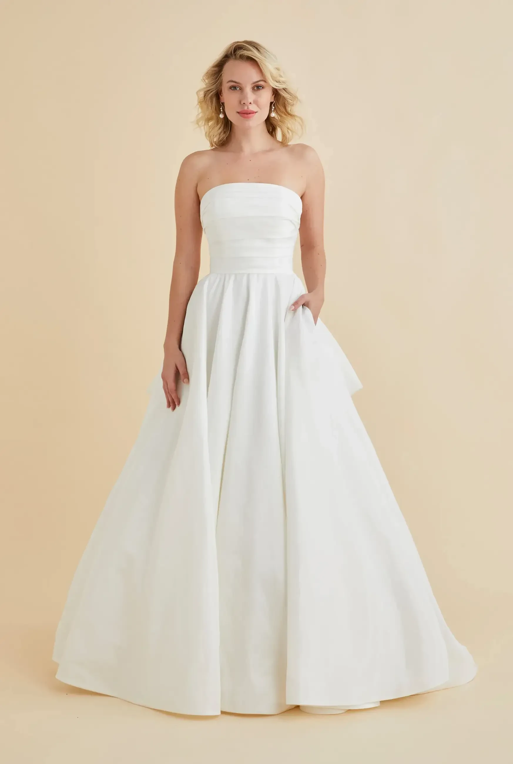 model is wearing a strapless ball gown wedding dress