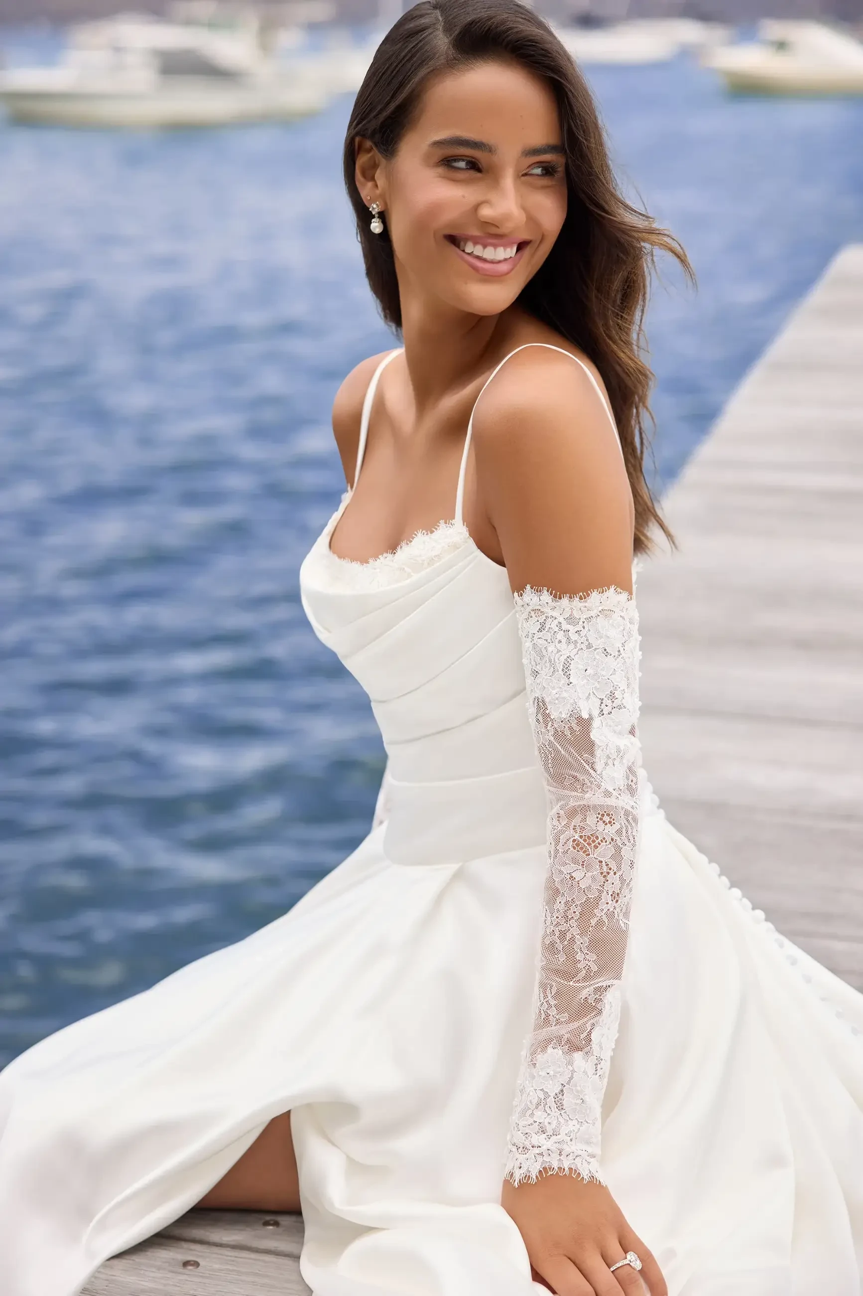 model is wearing an off the shoulder wedding dress with gauntlet sleeves